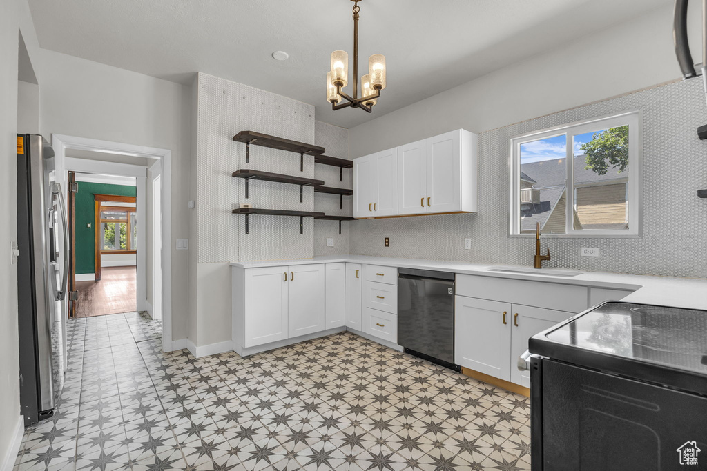 Kitchen with dishwashing machine, stainless steel fridge with ice dispenser, electric range, light floors, and a chandelier