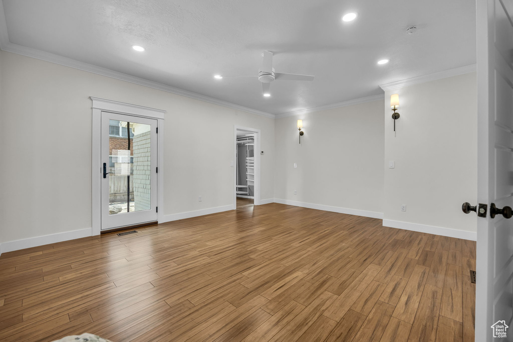 Empty room with a ceiling fan, crown molding, wood finished floors, recessed lighting, and a smoke detector