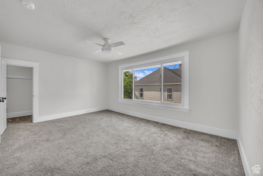 Unfurnished bedroom with carpet floors, a textured ceiling, and a ceiling fan