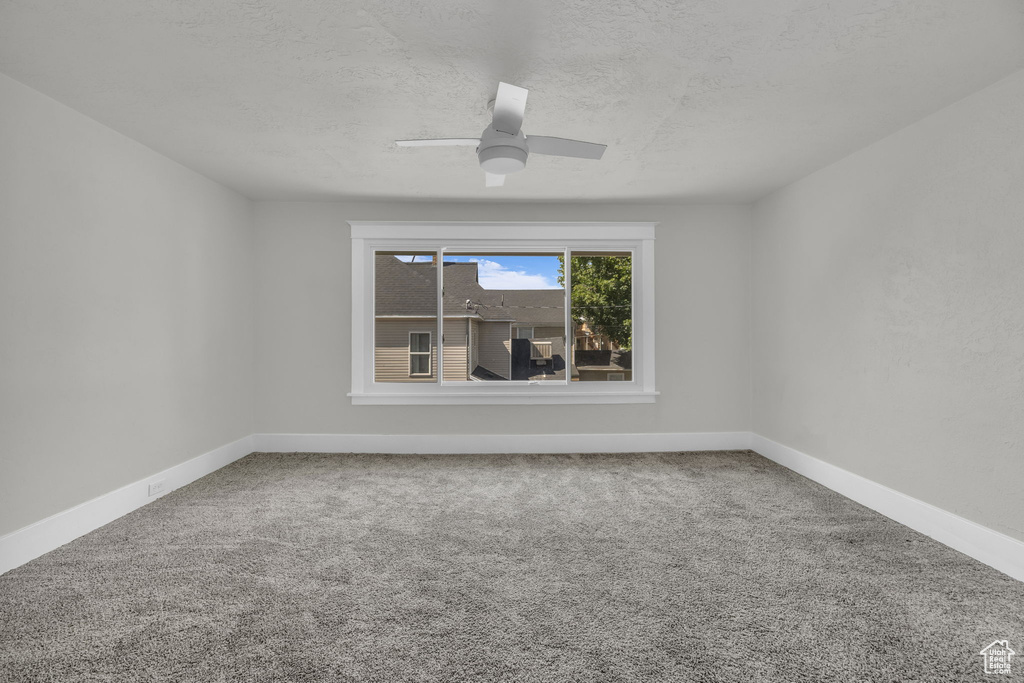 Unfurnished room with carpet, a textured ceiling, and a ceiling fan