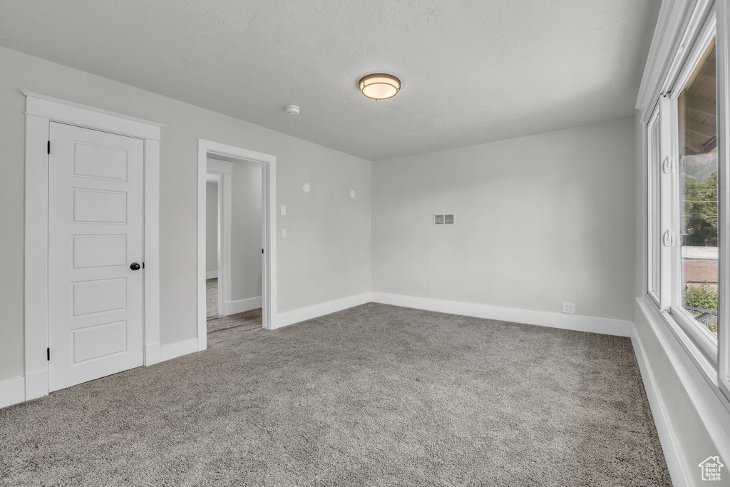 Unfurnished room with carpet and a smoke detector