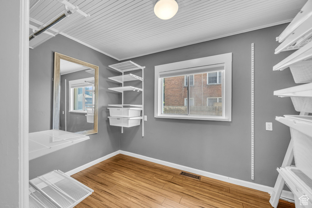 Walk in closet with wood finished floors