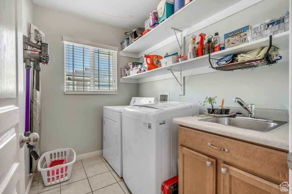 Laundry room featuring independent washer and dryer, cabinet space, and light tile patterned floors