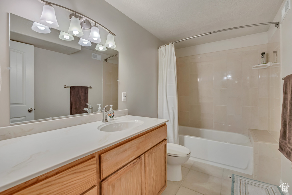 Bathroom with tile patterned floors, shower / bathtub combination with curtain, and vanity