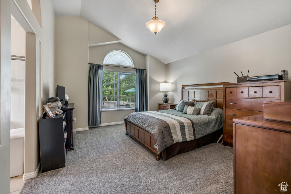 Carpeted bedroom featuring vaulted ceiling and baseboards