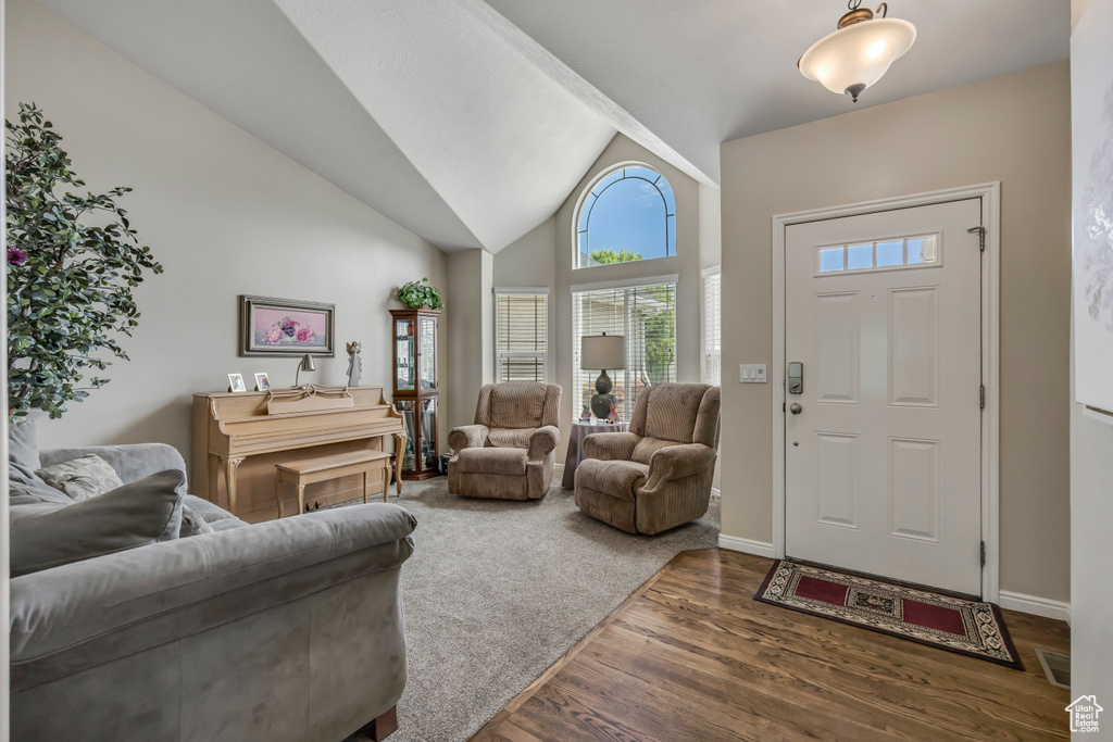 Foyer featuring wood finished floors and high vaulted ceiling