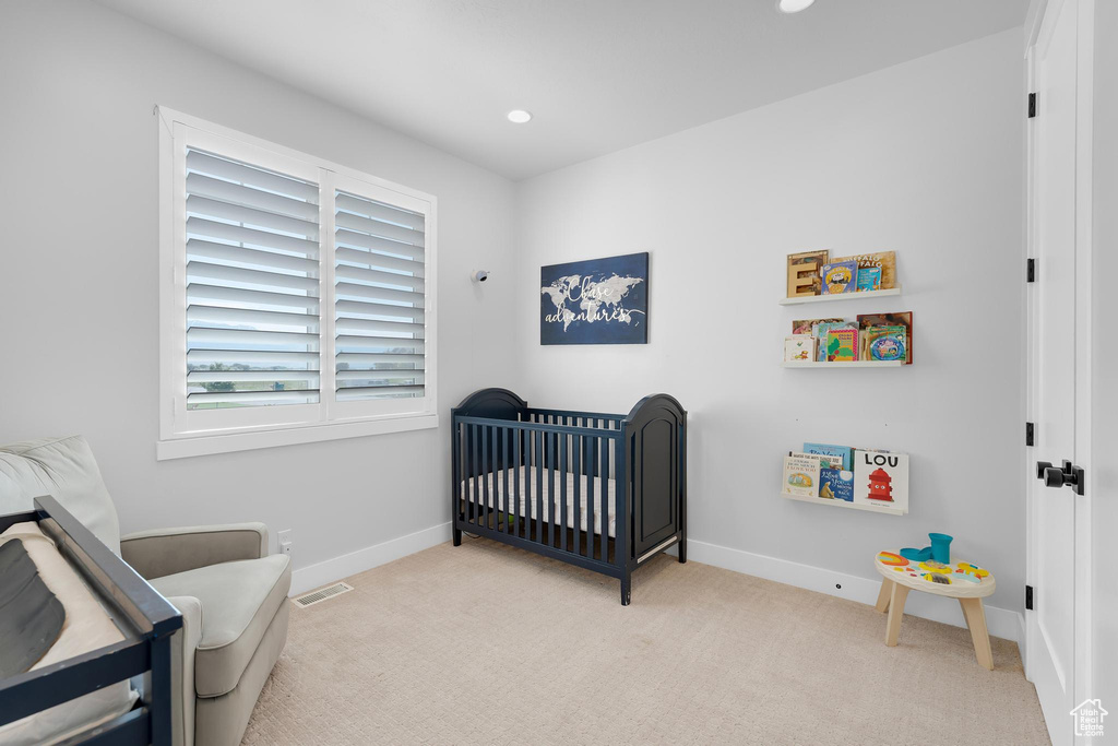 Carpeted bedroom featuring a crib and recessed lighting