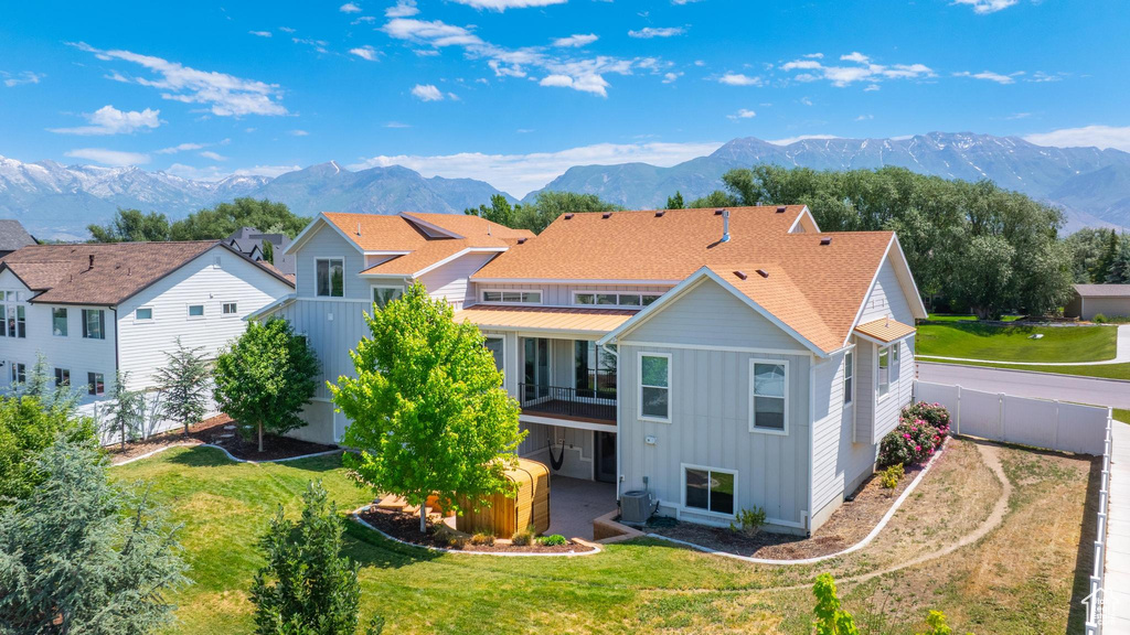 Back of house featuring board and batten siding, a mountain view, and a fenced backyard