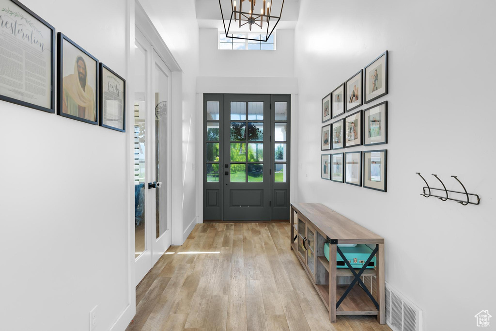 Foyer entrance featuring wood finished floors and a chandelier
