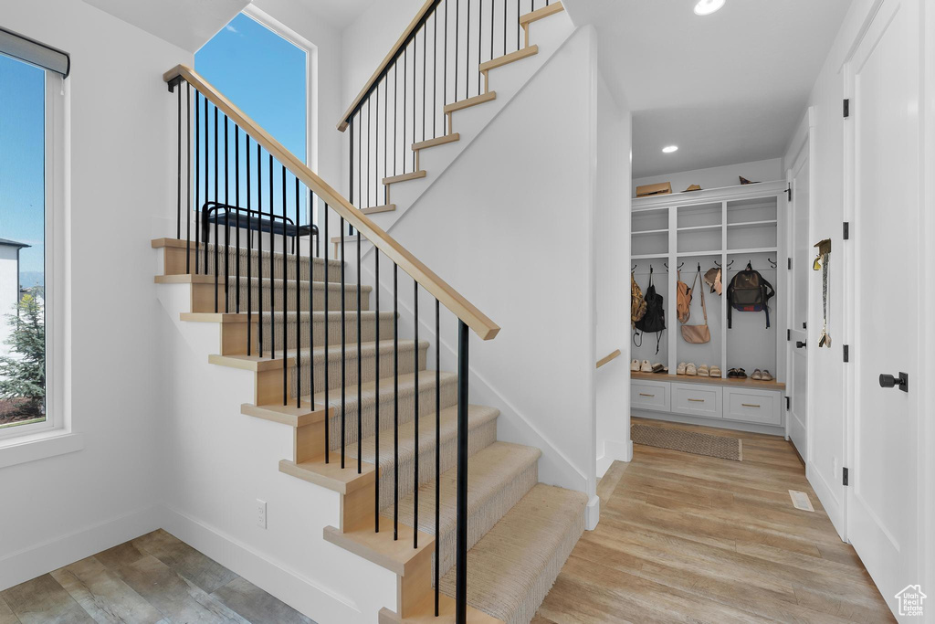 Stairs featuring wood finished floors and recessed lighting