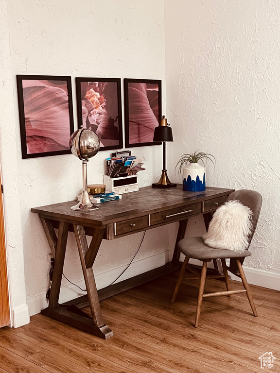 Office area featuring wood finished floors, baseboards, and a textured wall