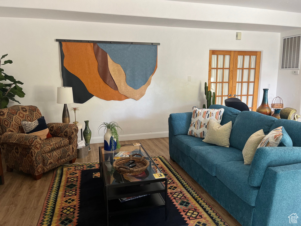 Living area with wood finished floors, baseboards, and french doors