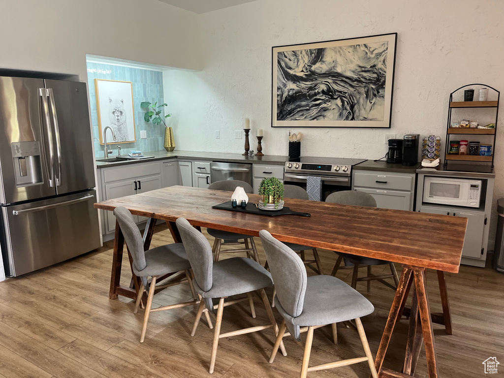 Dining space featuring light wood-style flooring and a textured wall