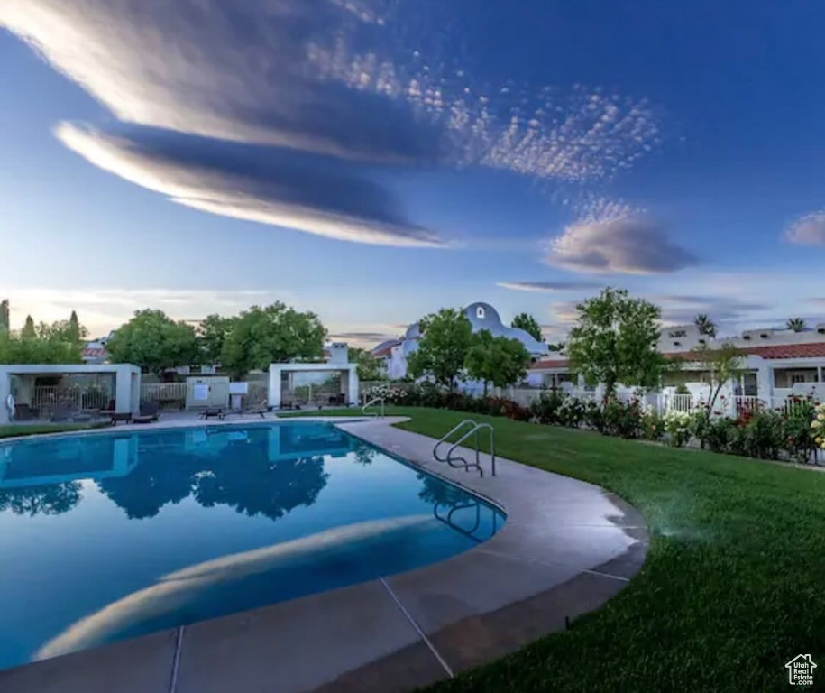 View of swimming pool with a yard and a patio