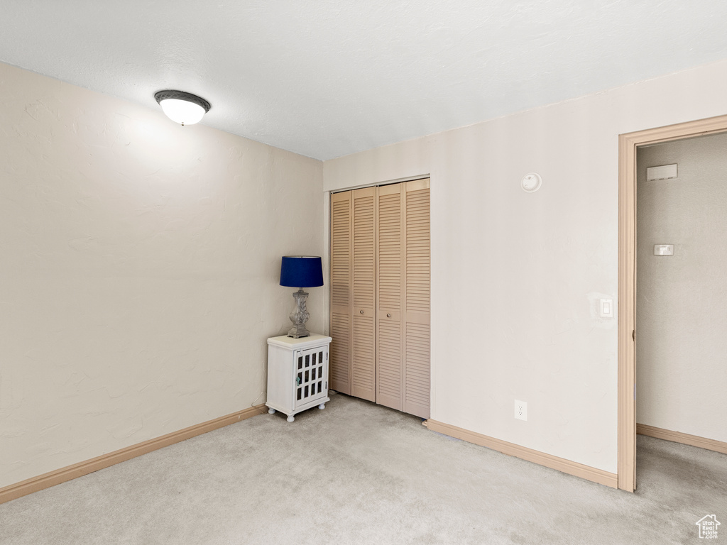 Unfurnished bedroom featuring carpet and a closet
