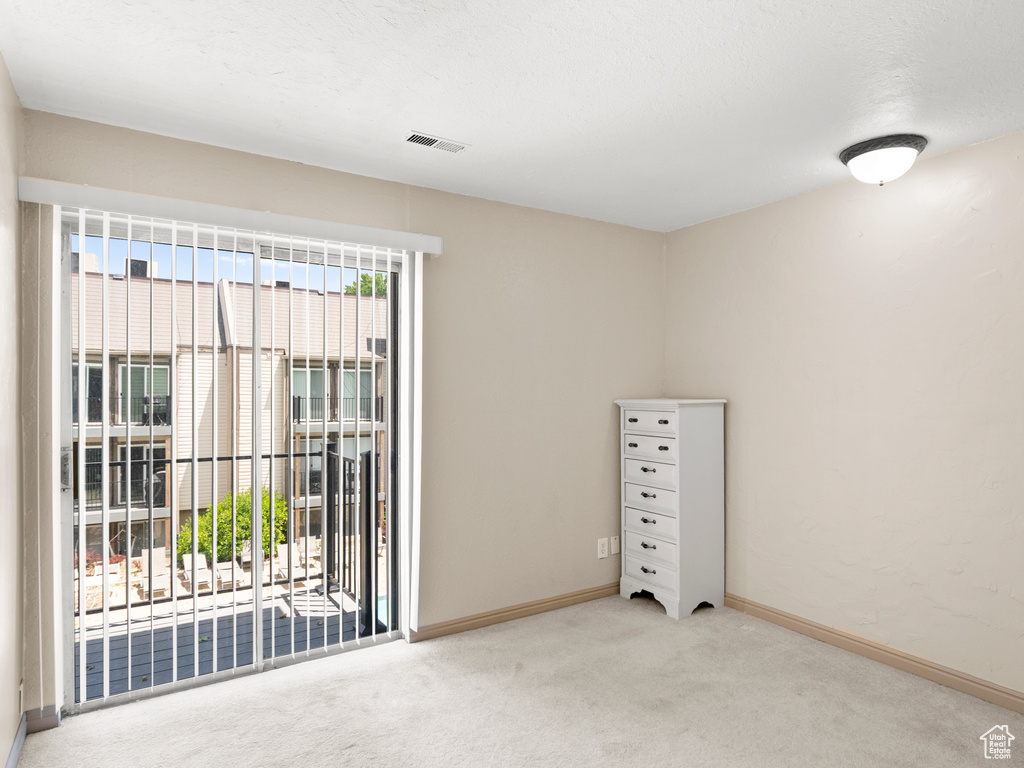 Spare room featuring carpet and baseboards