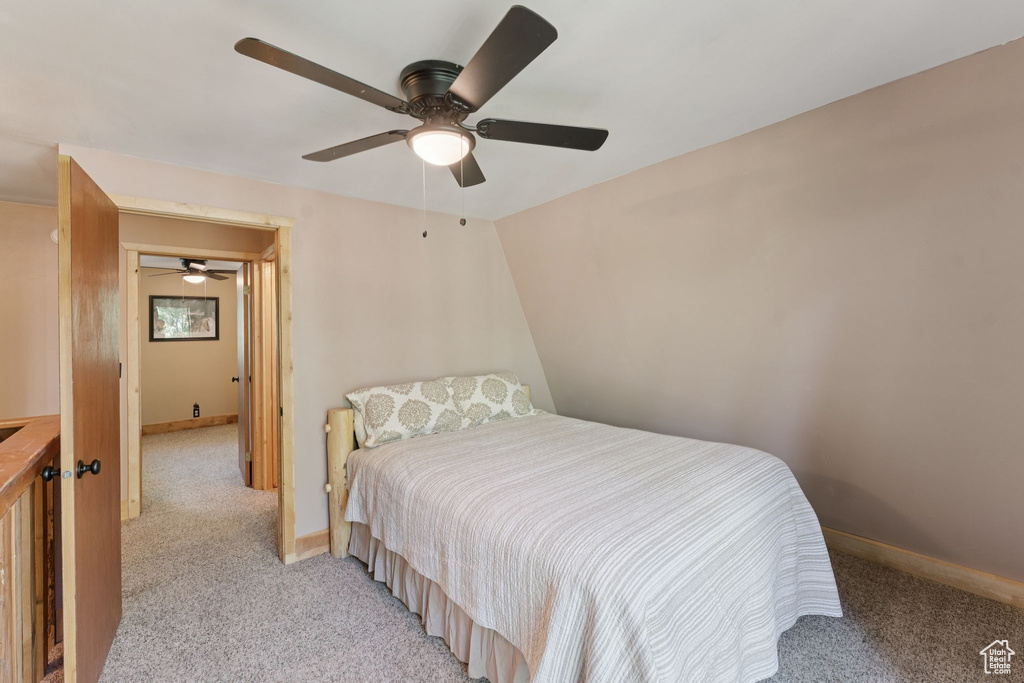 Bedroom with light colored carpet, baseboards, and a ceiling fan