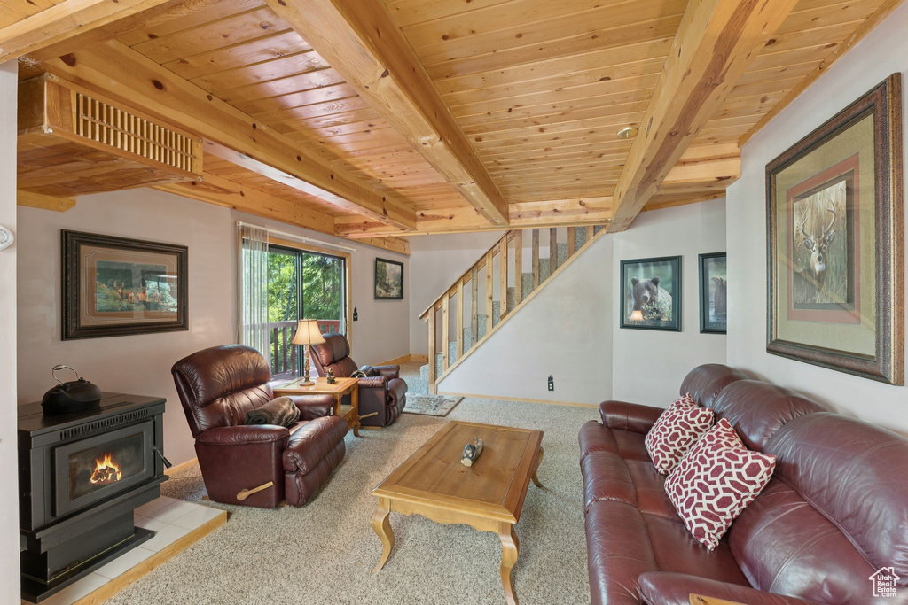 Carpeted living area featuring a wood stove, stairs, wood ceiling with exposed beams, and baseboards