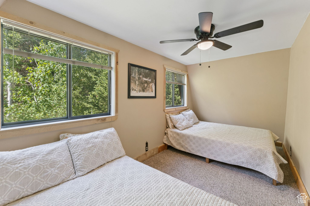 Carpeted bedroom featuring baseboards and ceiling fan