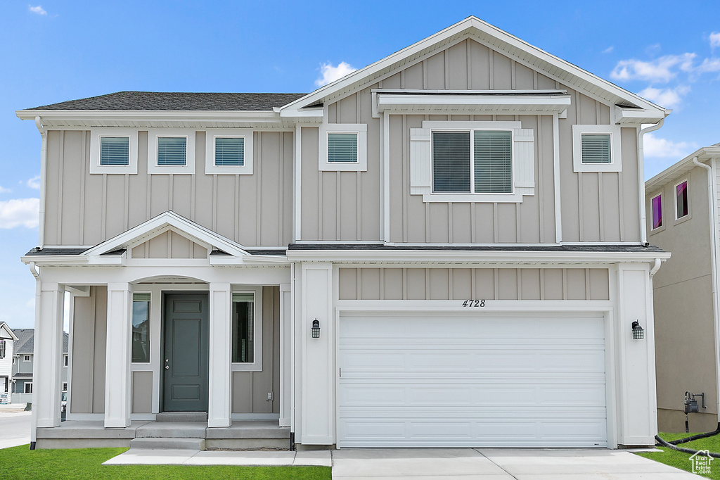 View of front of house featuring a garage, board and batten siding, concrete driveway, and a shingled roof