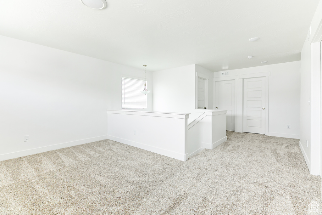 Spare room featuring light colored carpet and baseboards