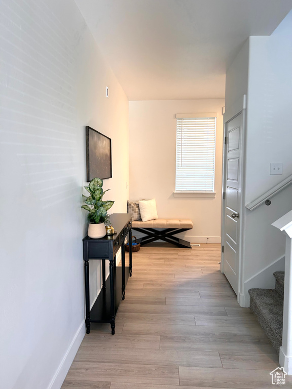 Corridor featuring stairway and wood finished floors