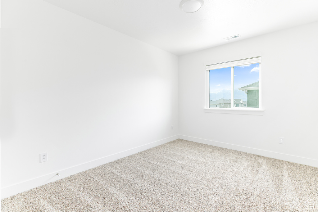 Carpeted empty room featuring baseboards