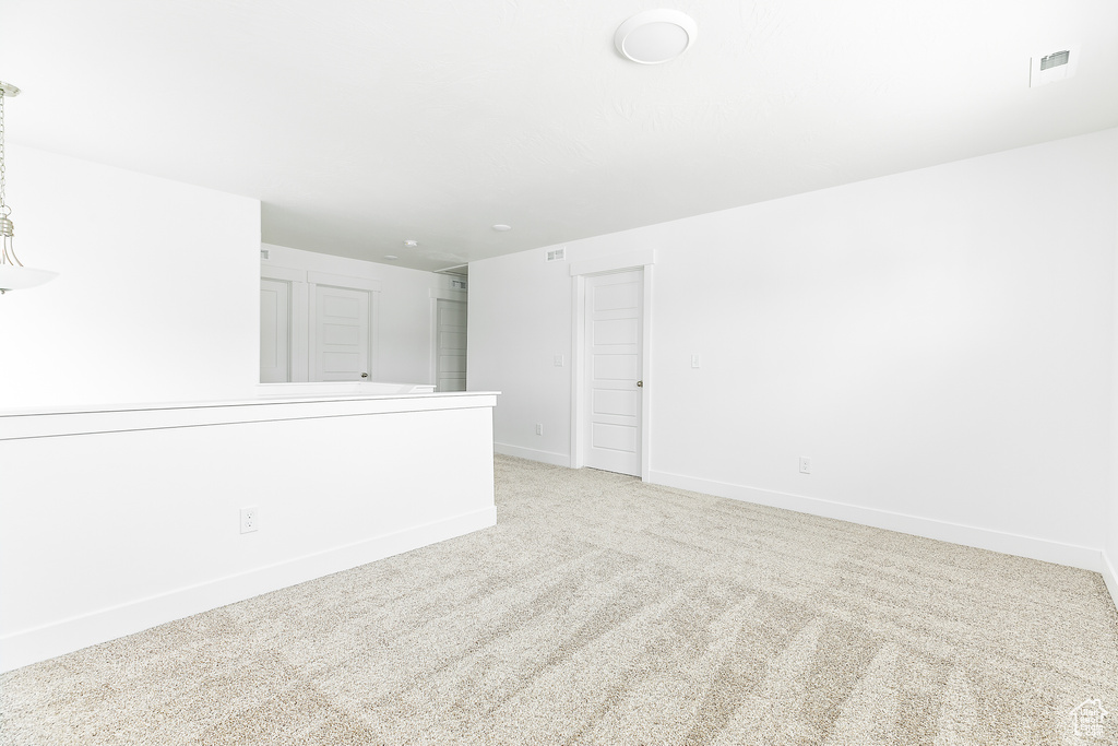 Unfurnished room with light carpet and baseboards