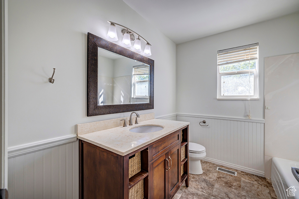 Bathroom with wainscoting, vanity, a tub, wooden walls, and a shower