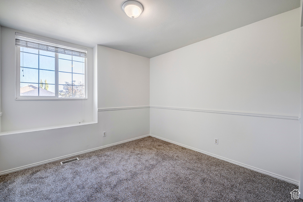 Carpeted empty room with baseboards