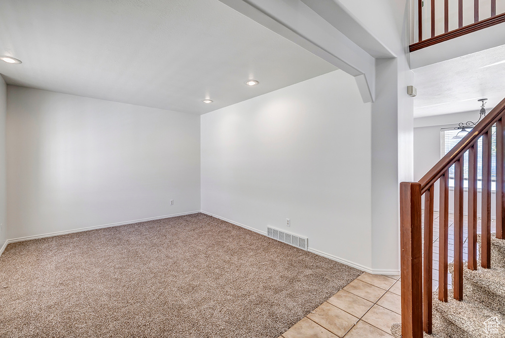 Unfurnished room featuring light carpet, recessed lighting, light tile patterned floors, and a chandelier