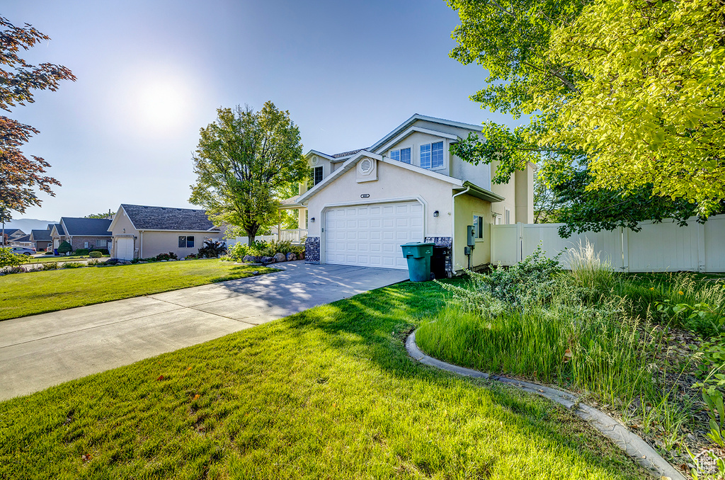 Traditional-style home featuring stucco siding, a garage, and concrete driveway