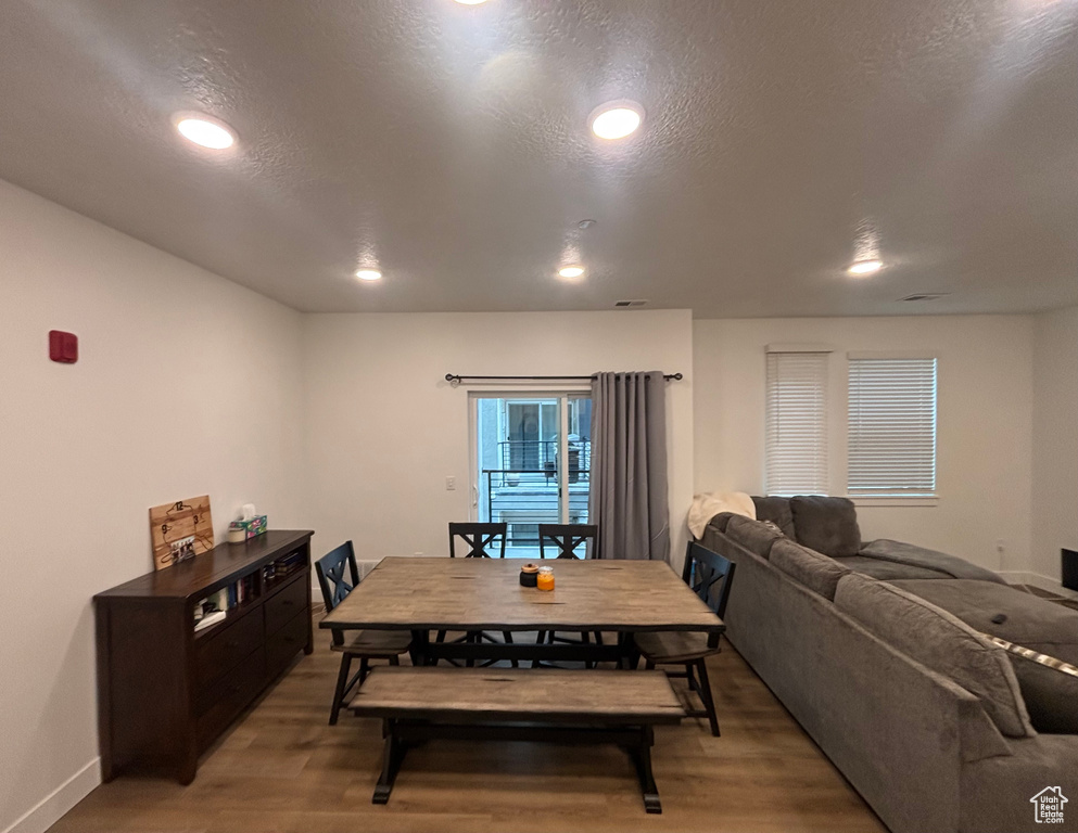 Dining area featuring light wood finished floors, recessed lighting, baseboards, and a textured ceiling