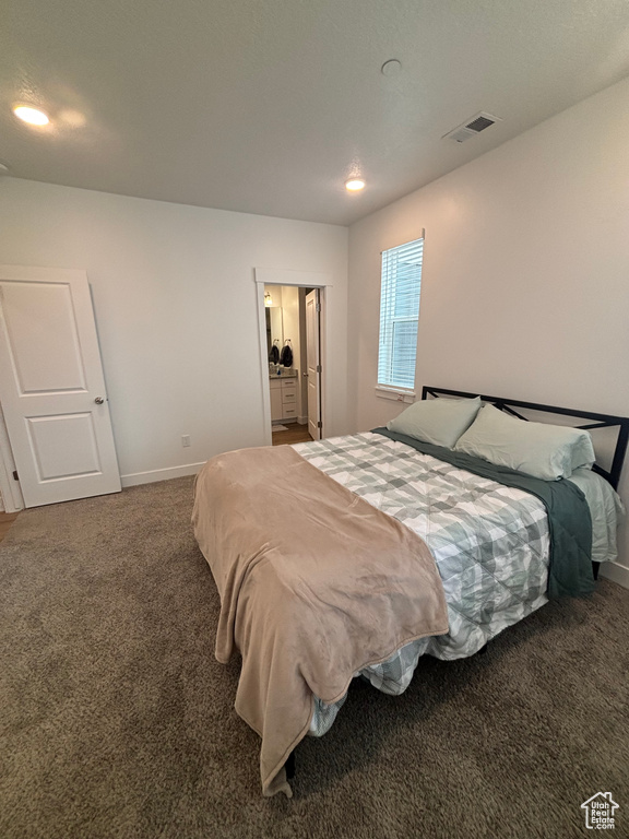 Carpeted bedroom featuring baseboards, recessed lighting, and ensuite bath