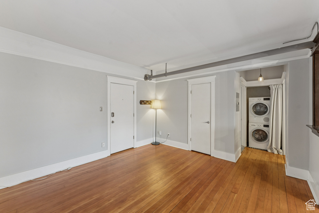 Unfurnished room featuring estacked washer and dryer and light wood-style floors