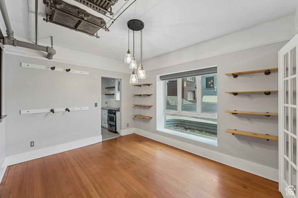 Unfurnished dining area with hardwood / wood-style flooring and baseboards
