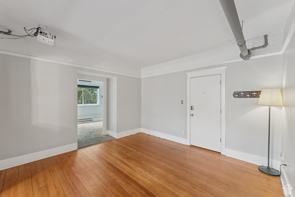 Spare room featuring light wood finished floors and a baseboard radiator