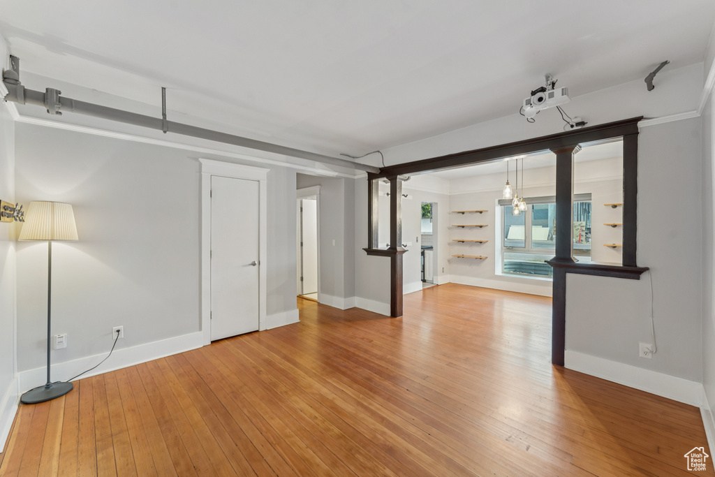 Empty room featuring light wood-type flooring and a chandelier