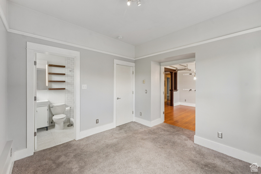 Unfurnished bedroom featuring carpet floors and ensuite bathroom