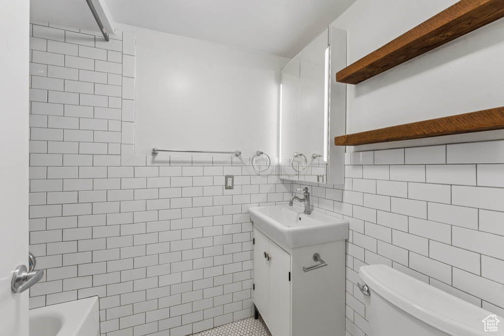Bathroom with vanity, tile walls, and bathtub / shower combination