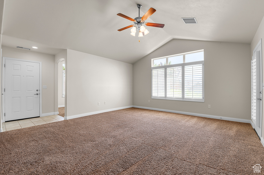 Unfurnished living room with light carpet, lofted ceiling, and a ceiling fan