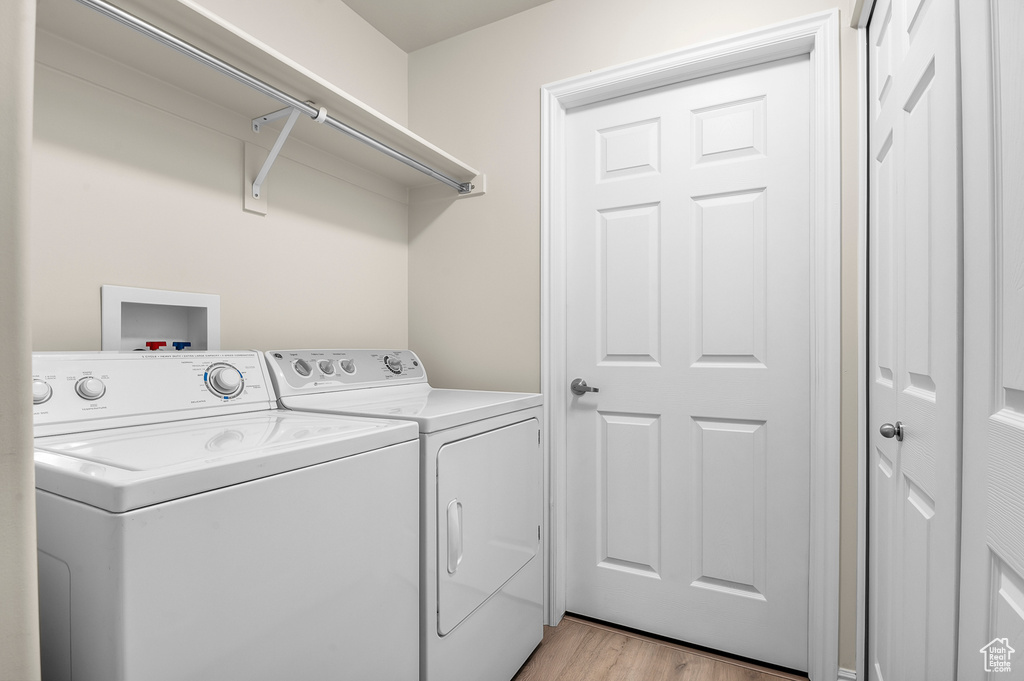 Laundry area featuring independent washer and dryer and light wood-style flooring