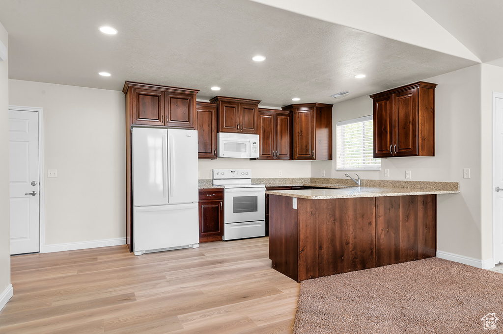 Kitchen with white appliances, recessed lighting, a peninsula, light wood-style floors, and dark brown cabinetry