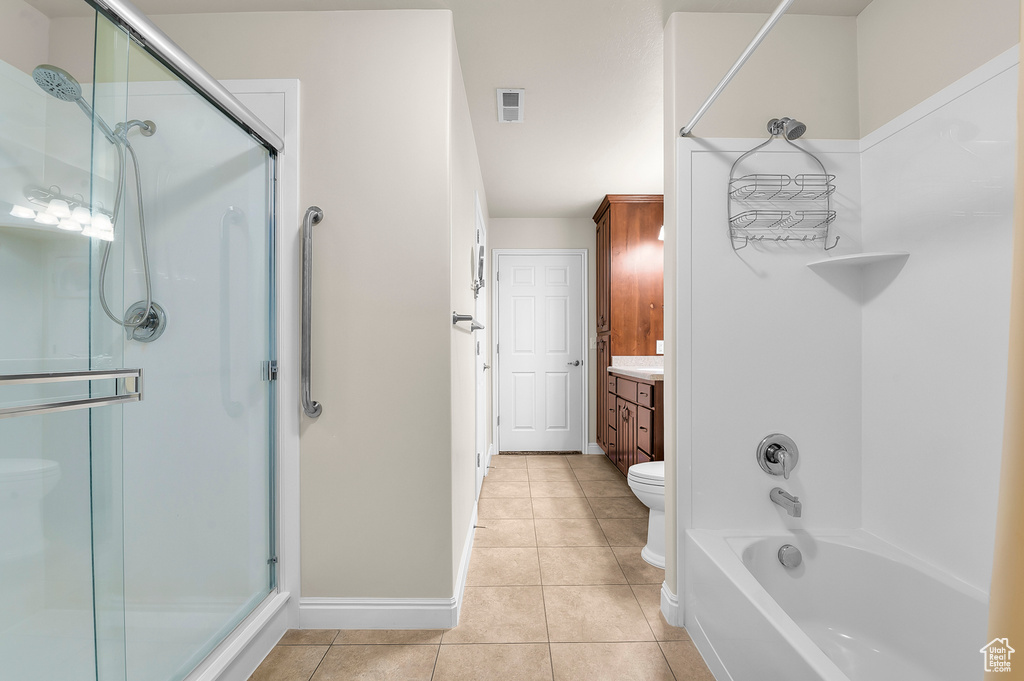 Bathroom with a shower with door, tile patterned floors, and vanity
