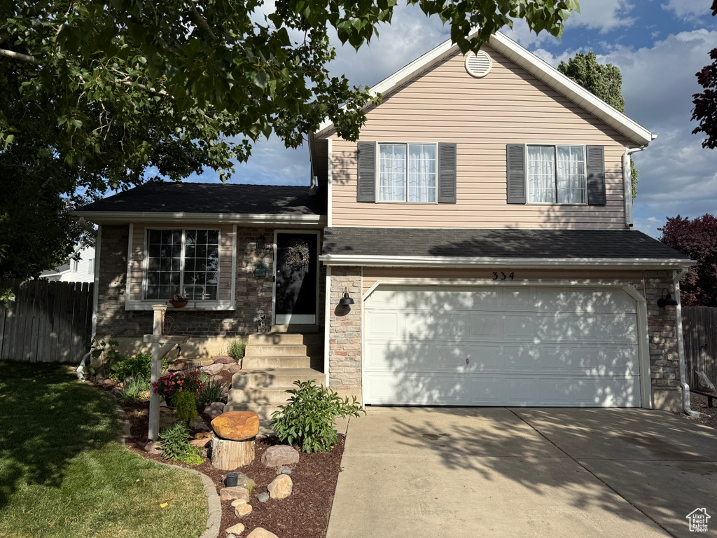 Split level home with an attached garage and concrete driveway