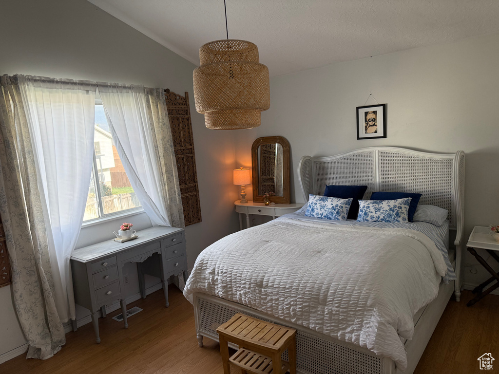 Bedroom with wood finished floors and vaulted ceiling