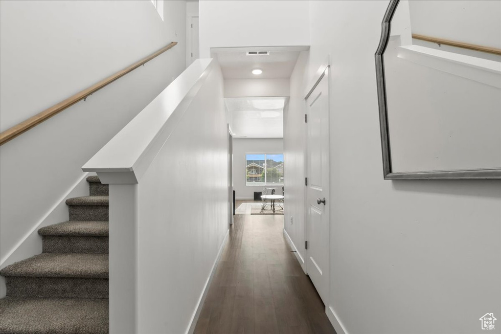 Staircase with wood finished floors and baseboards