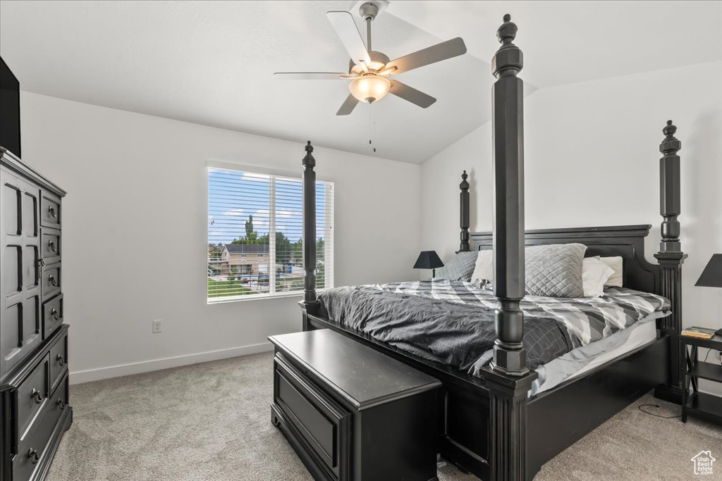 Bedroom with light carpet, vaulted ceiling, and ceiling fan