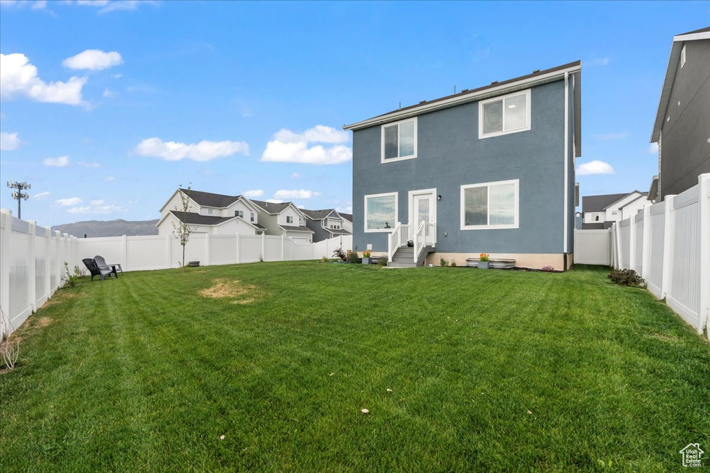 Rear view of property featuring a fenced backyard and stucco siding