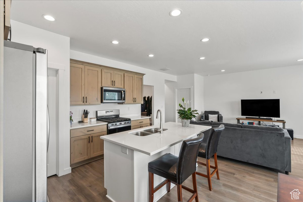 Kitchen featuring stainless steel appliances, dark wood-type flooring, light countertops, open floor plan, and recessed lighting
